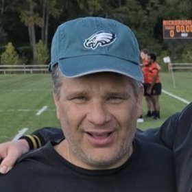 A Vivid Properties team member smiling in a Philadelphia Eagles cap